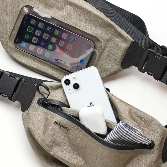 Sand Bitplay AquaSeal IPX7 Waterproof Sling Bag with Strap Adapter with phone case and smartphone inside, on a white background