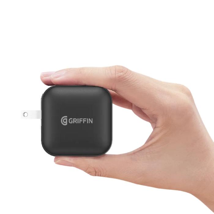 Hand holding a Black GRIFFIN PowerBlock 100w GaN PD3.0 Fast Charging Wall Charger on a white background
